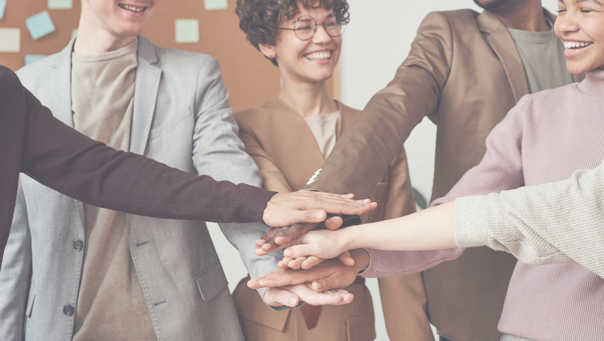Team of people with hands stacked on top of each other – symbol of collaboration and teamwork